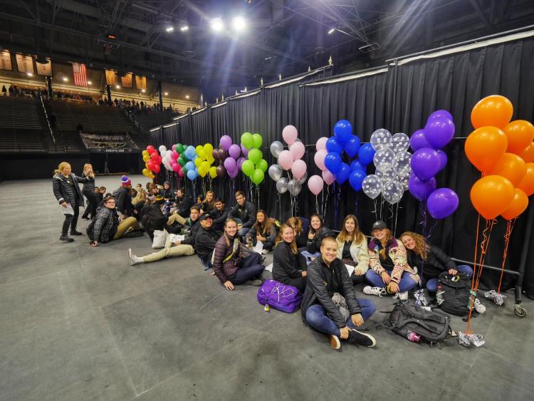 Group leaders hide behind the stage before leading admitted students and their parents to their respective areas of interest. Photo by Glenn Asakawa.