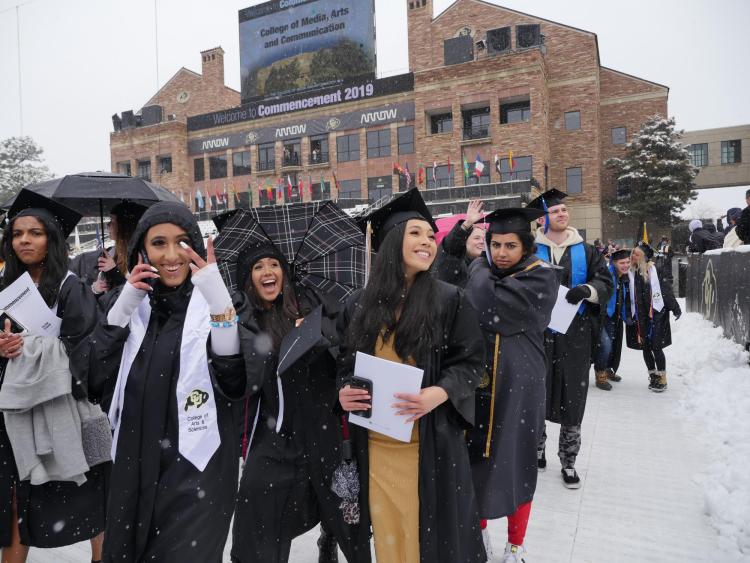 Graduates seated for commencement ceremony at Folsom Field