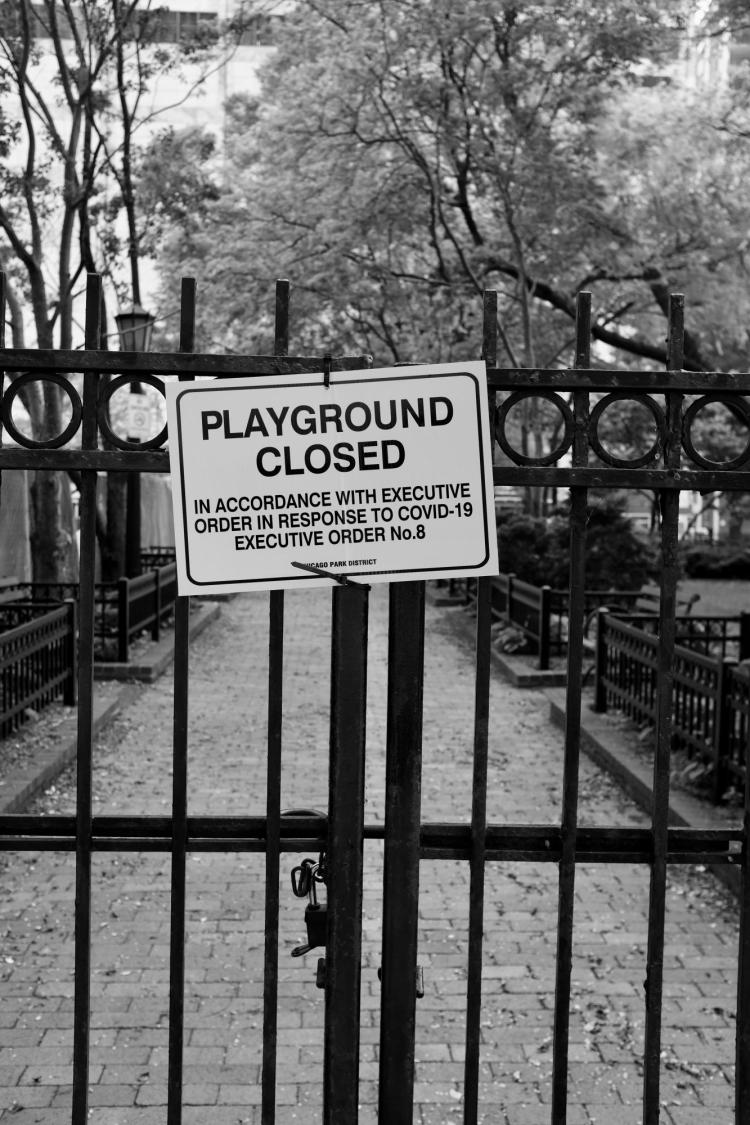 Sign on iron gate reads: 'Playground closed in accordance with executive order in response to COVID-19'