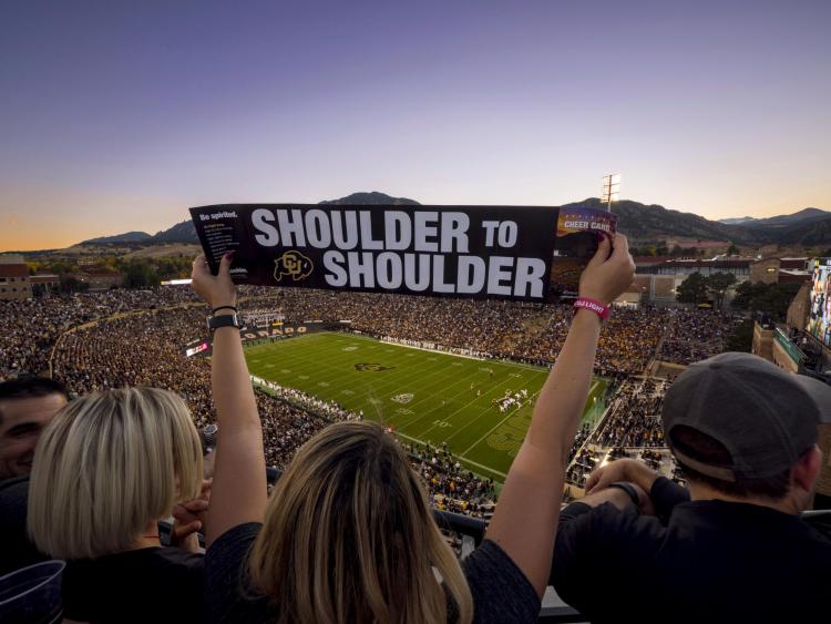 A "shoulder to shoulder" sign at a homecoming football game.