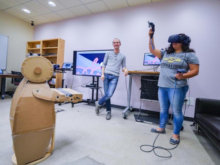 Peter Gyory, left, shows Taylor Salazar how using a low quality prototype to trace in VR can help industrial designers. Photo by Glenn Asakawa.