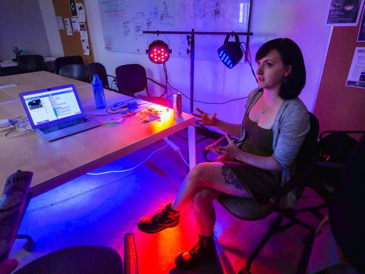 Annie Kelly explains her customizable and programmable concert lights that can be operated by a foot switch. Photo by Glenn Asakawa.