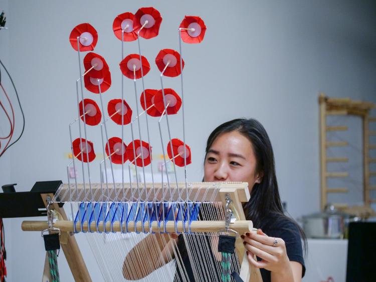 Jennifer Mah prepares her wind loom at the ATLAS Research Showcase. Photo by Glenn Asakawa.