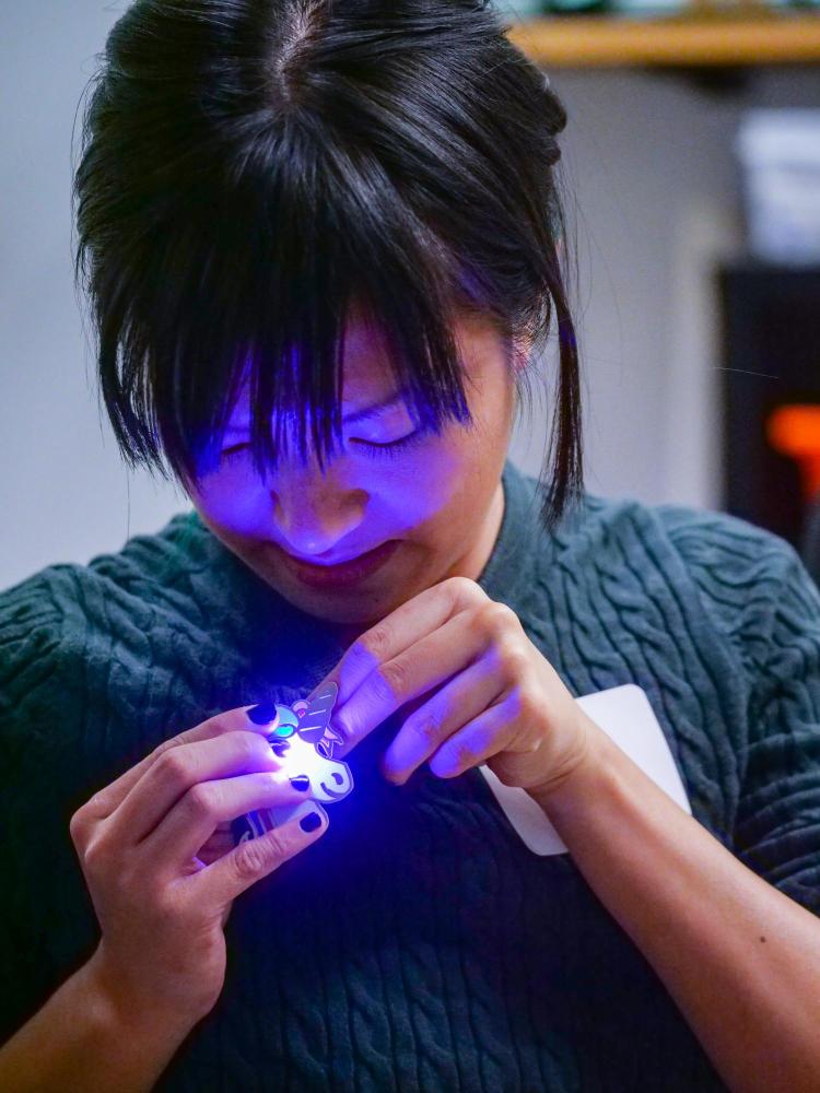 Boulder resident Alica Poon makes an LED-light unicorn pin at one of the ATLAS Research Showcase project areas. Photo by Glenn Asakawa.
