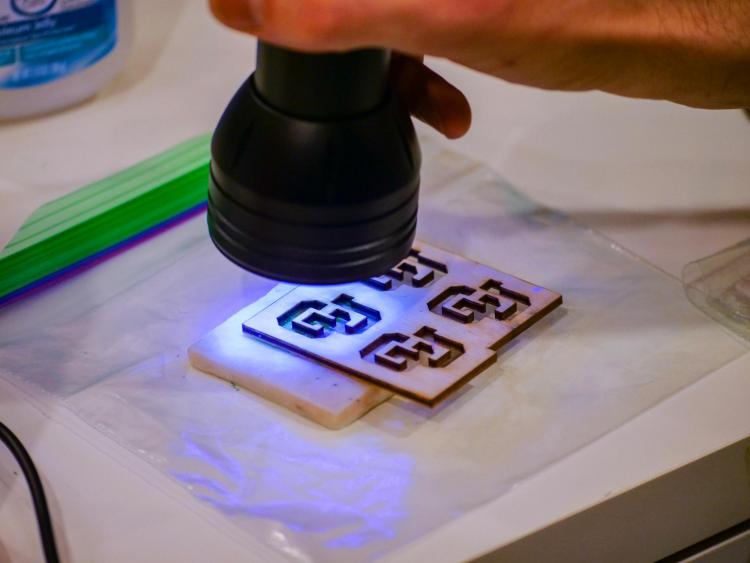 Assistant Professor Carson Burns demonstrates "tech tattoos" that change color in response to different stimuli. Photo by Glenn Asakawa.