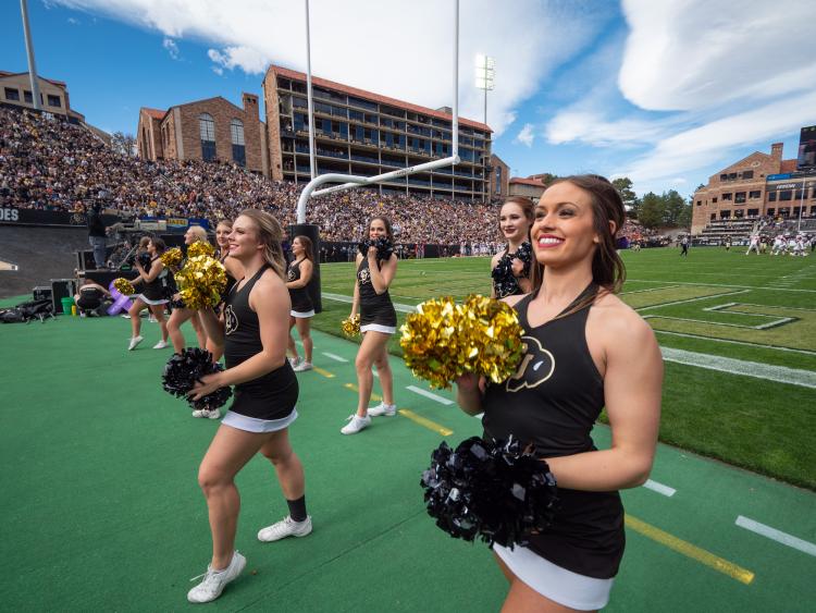 Cheerleaders on the sidelines of a Homecoming football game