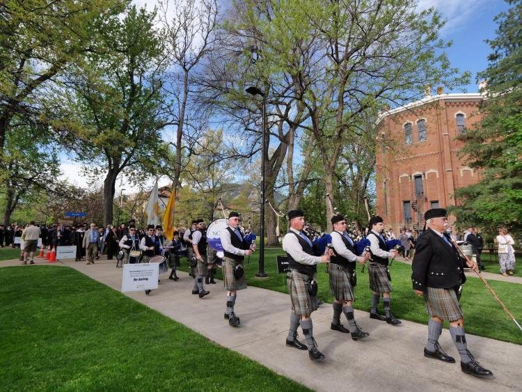 Bagpipers lead the procession from the quad to CU Boulder's 2018 main commencement ceremony at Folsom Field. Photo by Glenn Asakawa.
