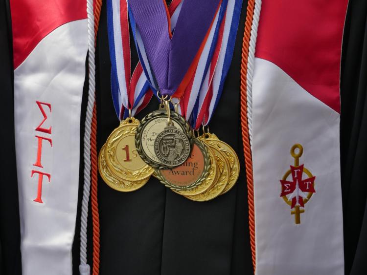 Graduate dons many medals during the commencement ceremony. Photo by Glenn Asakawa.