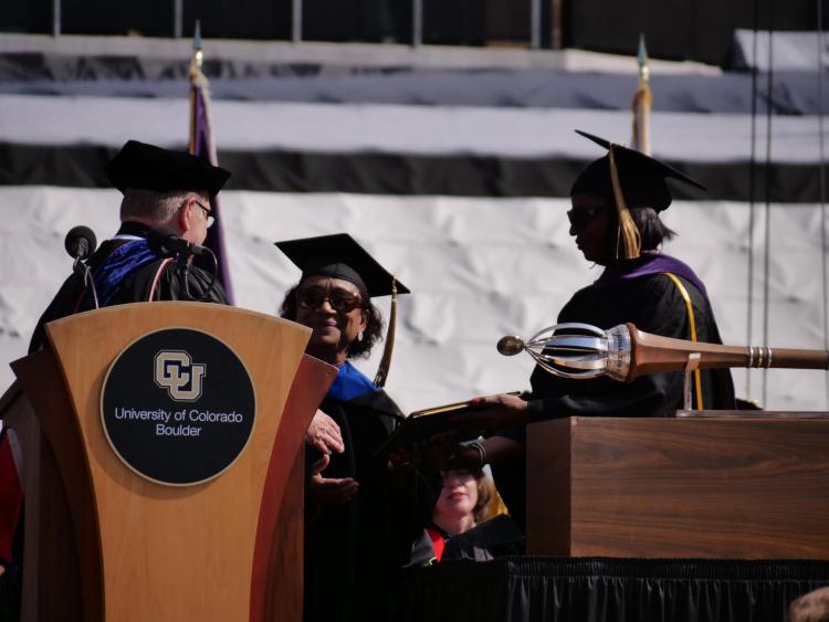 Polly McLean, center, CU associate professor of media studies accepts Lucile Berkely Buchanan's degree, posthumously, on her behalf. Photo by Glenn Asakawa.