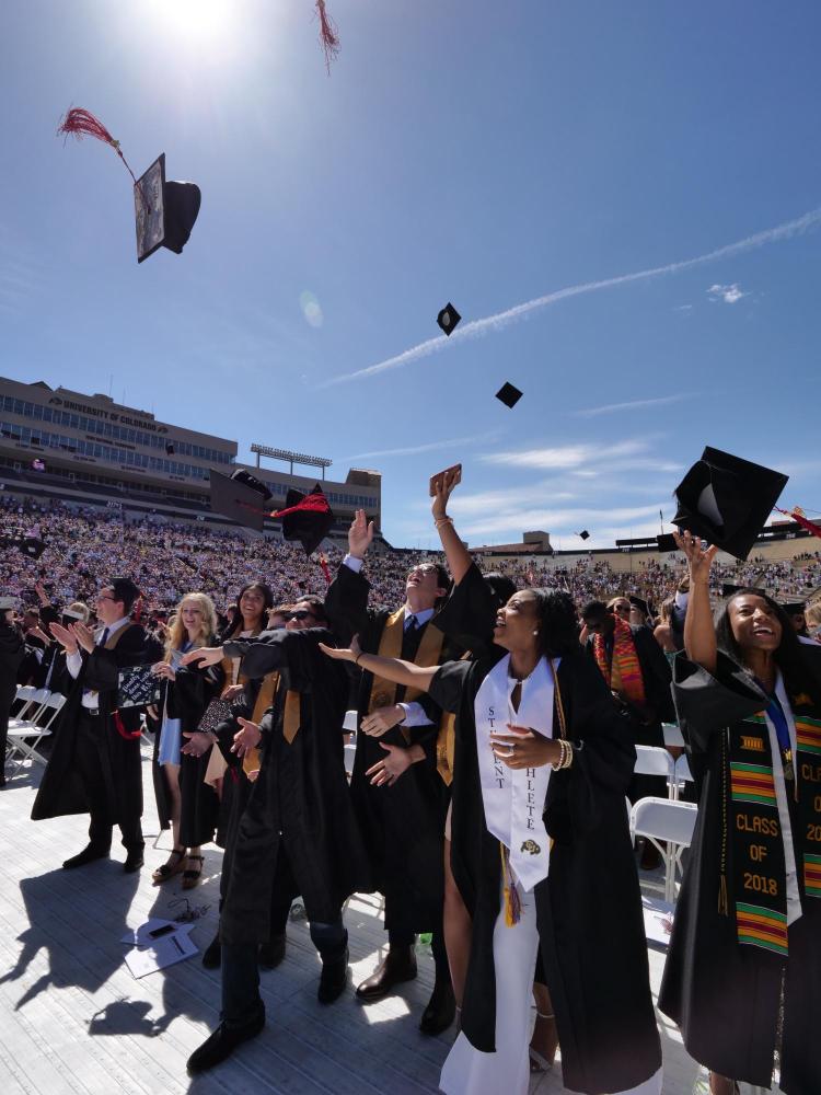 Graduates toss their caps up in the air as the ceremony comes to an end. Photo by Glenn Asakawa.