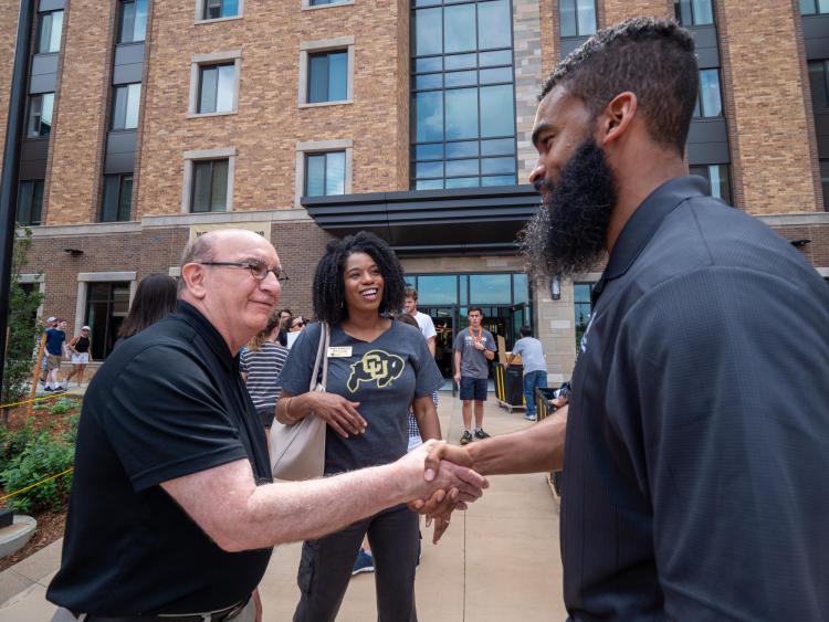 Chancellor Phil DiStefano, left, greets Hall Director Otis Johnson as Associate Vice Chancellor for Student Affairs Akirah Bradley, looks on during move-in on Wednesday, Aug. 21, 2019, at Williams Village East. (Photo by Glenn Asakawa/University of Colorado)