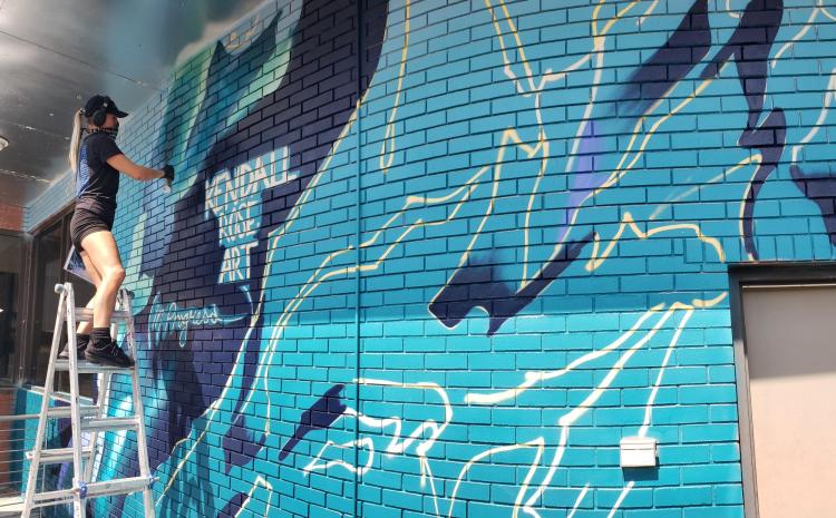 Artist Kendall Rose Kippley paints a mural in Boulder showing Arctic sea ice loss over time, based on NSIDC data. (Photo by Seamus McAfee, NSIDC)