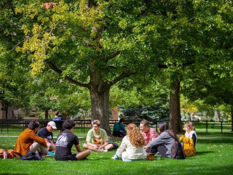 Students sit in a circle on Norlin Quad