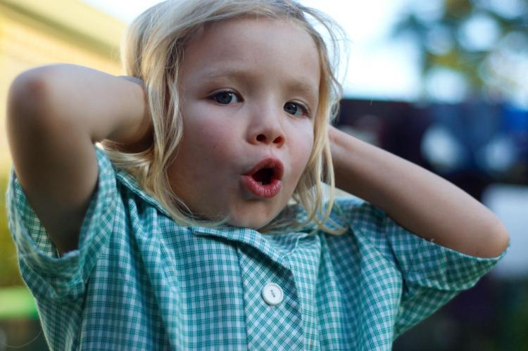 Little girl holds her hands over her ears