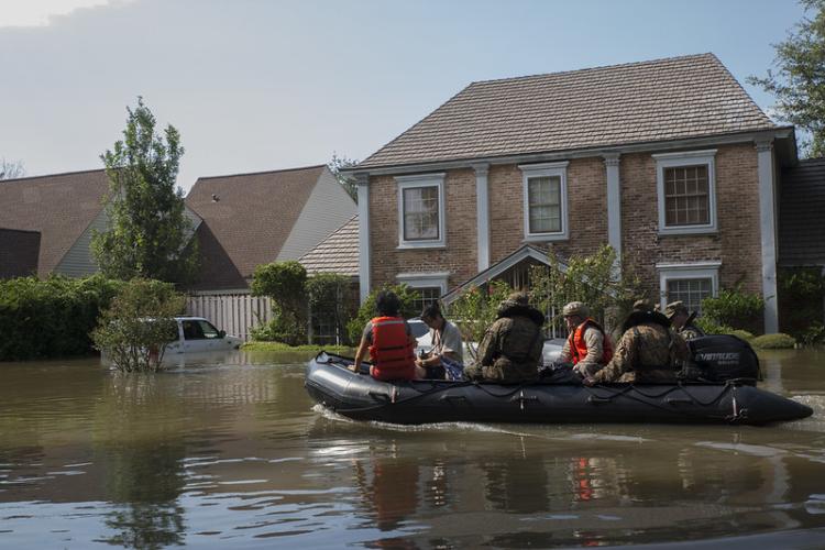 A Marine, a member of the Texas Highway Patrol and Texas State Guard escort a couple to higher ground, Houston, Texas, Aug. 31, 2017