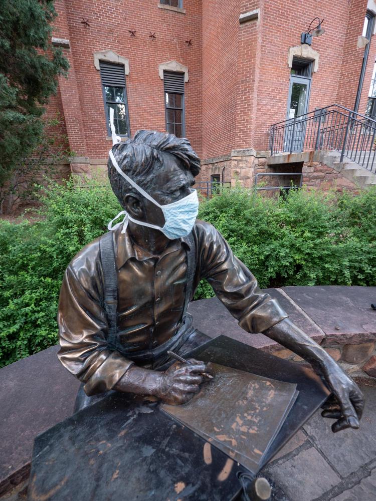 Robert Frost sculpture wearing a mask