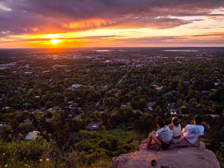three friends watch the sunrise at Flagstaff