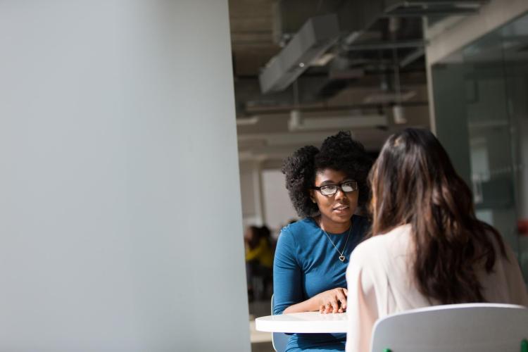 Two women sitting at a table and talking