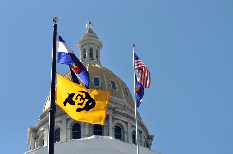 Several flags -- CU's, the state of Colorado's and the United State's -- are raised near the Colorado state capitol.