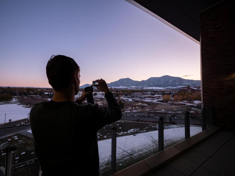 A visitor to the Aerospace Building takes a photo of the view during sunset