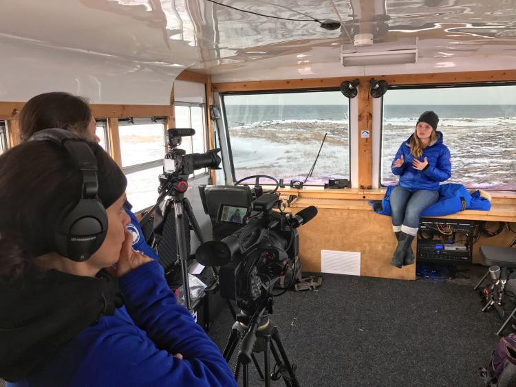 Student filming on a boat in the arctic