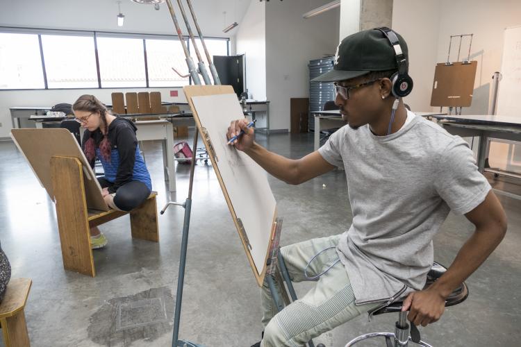 Student works on art piece in the classroom