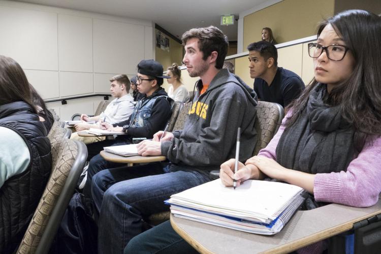 Students listen to lecture in a large classroom