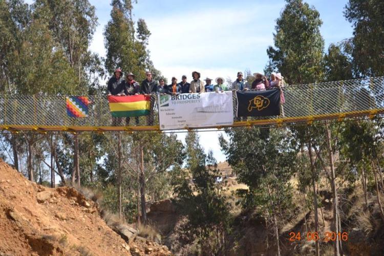 CU Boulder engineering students stand on completed bridge