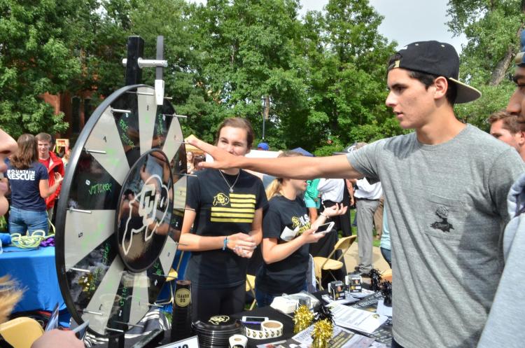 Student spins a wheel at a past Be Involved Fair