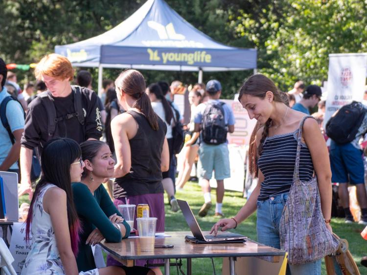 Student visits a table at the Be Involved Fair