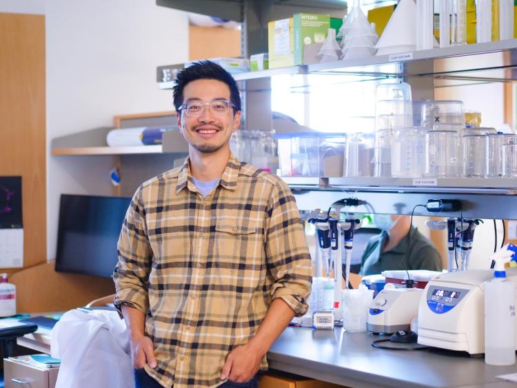 man stands in front of a laboratory bench with scientific equipment