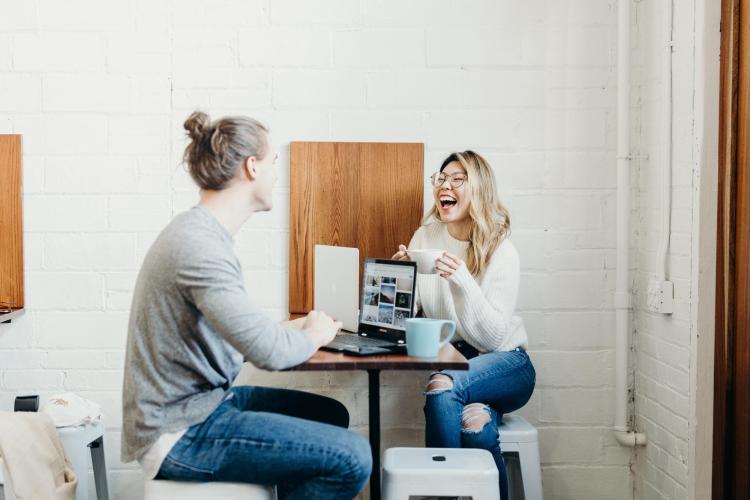 two people working on laptops and drinking coffee