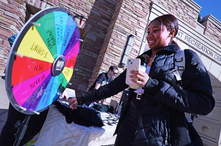 Student spinning a prize wheel at the Buffs All-in Giving Day