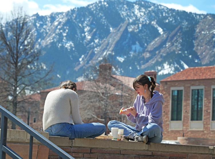Two students eating lunch outside on campus
