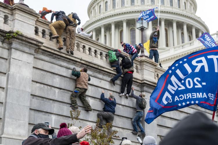 Rioters scale a wall at the Capitol on January 6, 2021. (Credit: CC image via Flickr)