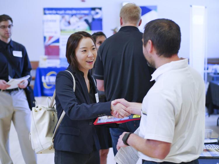 Student shakes hands with employer at last year's Just in Time Career Fair