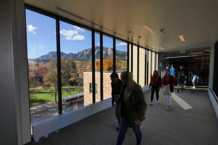 Campus community members walk through CASE building near panoramic window
