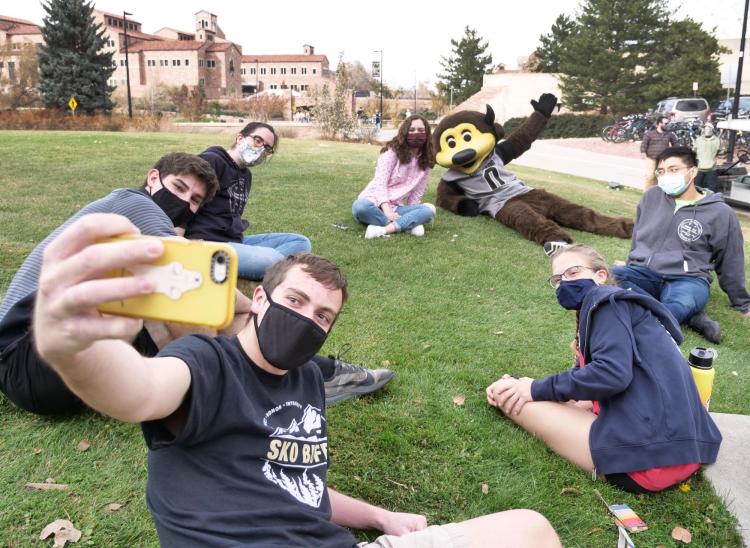 Students gather for a selfie with Chip the buffalo mascot outside
