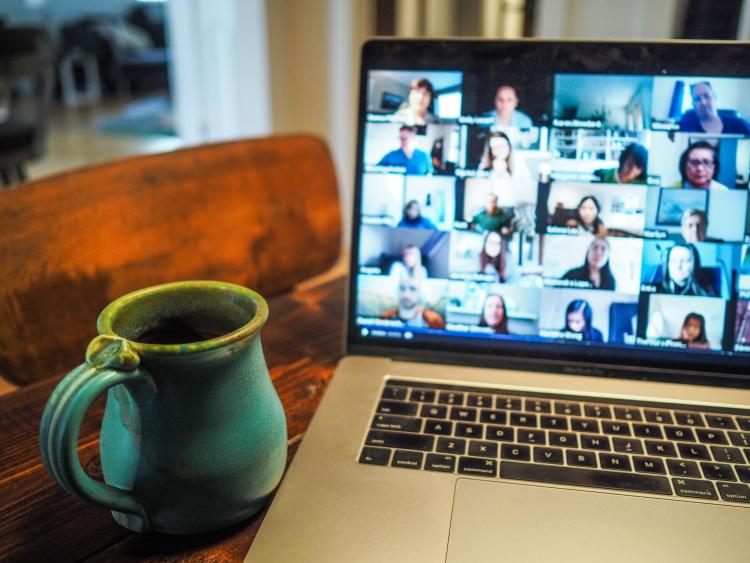 coffee mug and Zoom conference on laptop