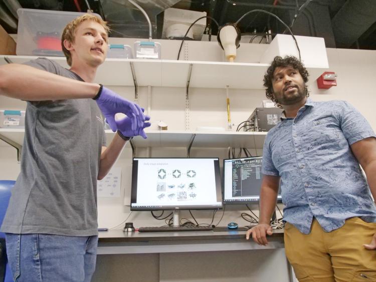 Two men point to a computer screen