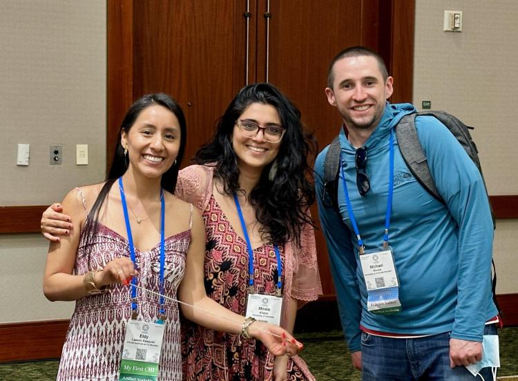 Photo of three people posing in a hallway
