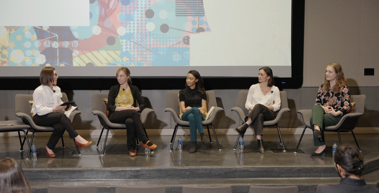 Featured speakers sit in a panel to take questions
