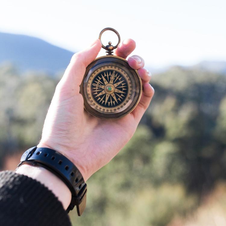 Woman holds out compass to determine direction