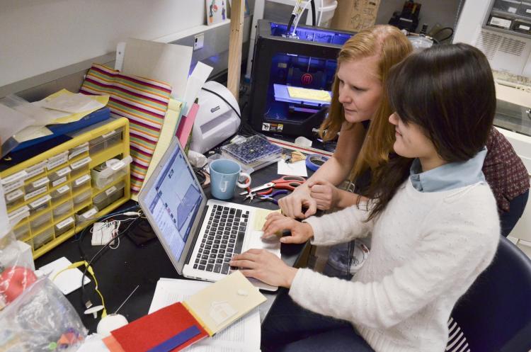 Students work at laptop computer