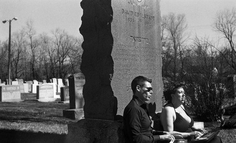 Two Archive Transformed residents sit against headstone