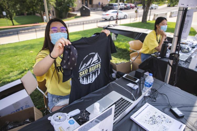 Volunteers pass out Sko Buffs t-shirts during move-in