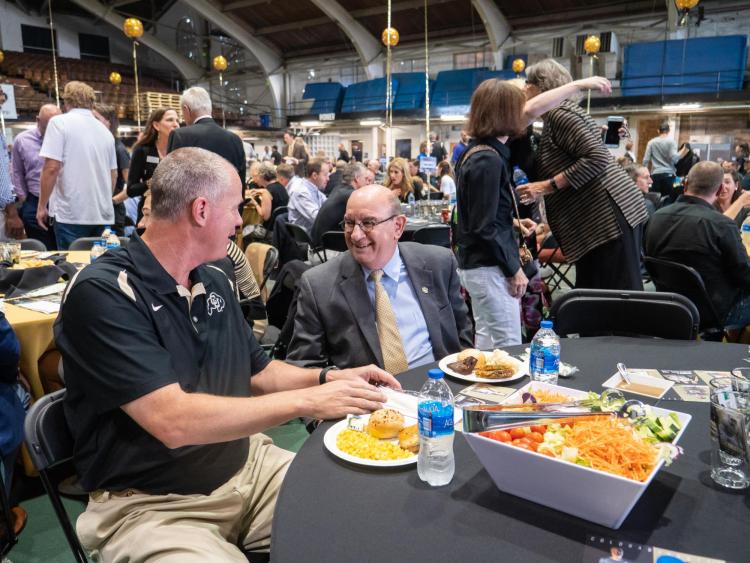 Chancellor DiStefano chats with CU basketball coach Tad Boyle at football kickoff luncheon.