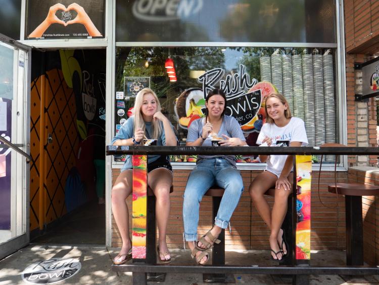 Students sit outside of Rush Bowls on The Hill