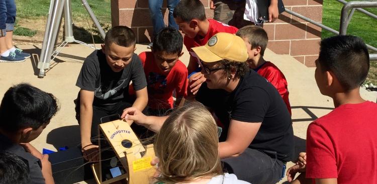 CU Boulder astronomy and physics student Sam Strabala searches for sunspots with middle schoolers in Keenesburg, Colorado as part of a science outreach program.