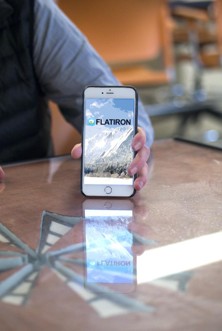 David Meyer holds his phone to display the Flatiron Chat app on screen